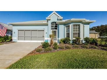 Light blue house with a well-manicured lawn and a two-car garage at 11443 Sinatra Ct, New Port Richey, FL 34654