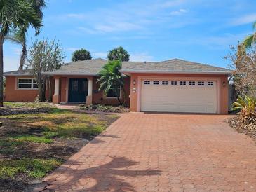 Charming single-story home featuring a brick driveway, lush landscaping, and a well-maintained two-car garage at 1285 79Th St S, St Petersburg, FL 33707