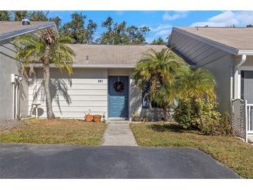 Charming townhome featuring well-maintained landscaping, a welcoming blue door, and a cozy, inviting atmosphere at 381 Estero Ct, Safety Harbor, FL 34695