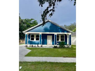 Charming blue house with a white trim, front yard, and driveway at 4202 N 15Th St, Tampa, FL 33610