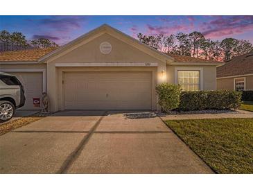 Well-maintained house with a two-car garage and manicured lawn at 5722 Autumn Shire Dr, Zephyrhills, FL 33541