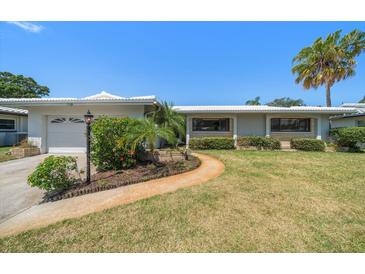 Charming single-story home with landscaped front yard and palm trees at 1388 S Hercules Ave, Clearwater, FL 33764