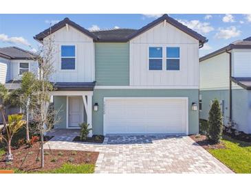 Charming two-story home with an attached two-car garage and colorful exterior at 10320 Cross River Trl, Parrish, FL 34219