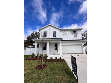 Charming two-story home features a well-manicured lawn and a classic white exterior at 709 W Orient St, Tampa, FL 33603