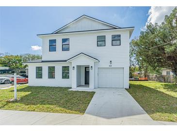 New two-story home showcasing black trim windows, attached garage and freshly installed lawn at 925 E Chelsea St, Tampa, FL 33603