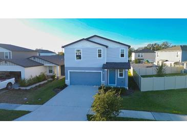 Two-story house with gray siding, a two-car garage, and a well-maintained lawn at 3314 Fresno Pl, Zephyrhills, FL 33541