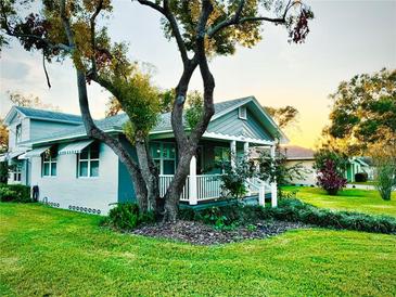 Charming home featuring a quaint front porch, well-maintained lawn, and mature landscaping at 1003 Beverly Ave, Largo, FL 33770