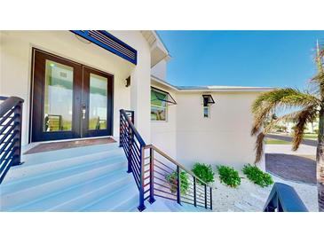 Inviting front entrance with modern black door and sleek black railings up to the house at 10101 Eagle Preserve Dr, Englewood, FL 34224