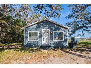 Gray house with white door and windows, surrounded by trees at 3106 E Trapnell Rd, Plant City, FL 33566