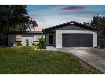 Charming ranch home with a modern black and white exterior, newly landscaped lawn and driveway at 612 E Wheeler Rd, Seffner, FL 33584