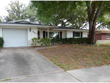 Ranch style home with a single car garage and a large front yard at 980 5Th Ne Ave, Largo, FL 33770