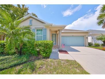 Single-story home with light beige exterior, blue shutters, and landscaped front yard at 6836 Park Strand Dr, Apollo Beach, FL 33572