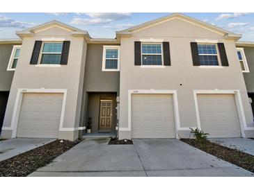 Three-unit townhome building with two-car garages and front entry at 1579 Hubbell Rd, Wesley Chapel, FL 33543