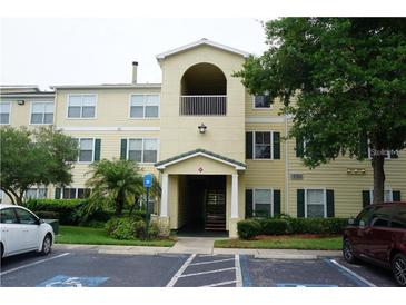 Two-story condo building with light yellow exterior, balconies, and ample parking at 18235 Bridle Club Dr # 18235, Tampa, FL 33647