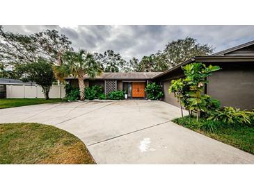 Mid-century modern home with circular driveway and lush landscaping at 3311 San Mateo St, Clearwater, FL 33759