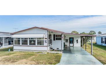 White single-wide manufactured home with carport and landscaped yard at 5244 Montego Dr, Zephyrhills, FL 33541