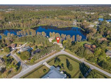 Beautiful aerial view of home on a spacious lot with lake frontage and mature trees creating a private setting at 905 Lake Fuller Dr, Lutz, FL 33548
