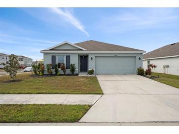 Single-story home with attached garage and landscaped front yard at 10303 Charlotte Dr, Parrish, FL 34219