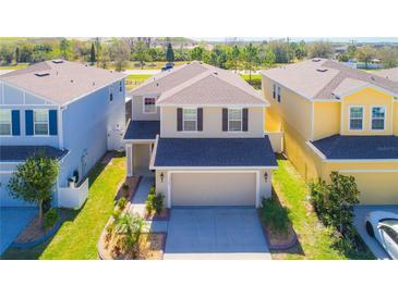 Two-story house with beige exterior, two-car garage, and landscaping at 11301 Hudson Hills Ln, Riverview, FL 33579