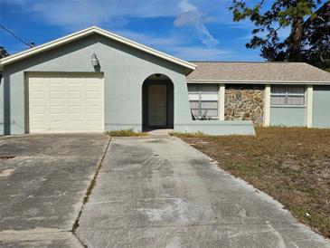 Ranch style home with attached garage and mature landscaping at 8627 Longboat Ln, Hudson, FL 34667