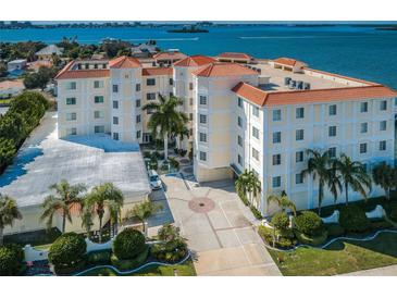 Beautiful waterfront building featuring lush landscaping and a circular driveway leading to the entrance at 1860 N Fort Harrison Ave # 104, Clearwater, FL 33755