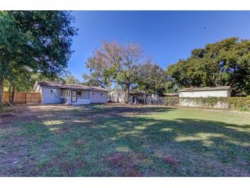 Spacious backyard with lush lawn and wooden fence at 5610 12Th St, Zephyrhills, FL 33542