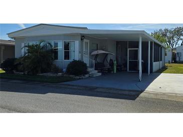 Mobile home with carport, screened porch, and landscaping at 125 Dolphin S Dr, Oldsmar, FL 34677