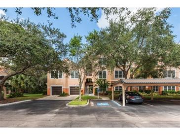 Exterior view of condo building with parking and landscaping at 4166 Central Sarasota Pkwy # 521, Sarasota, FL 34238