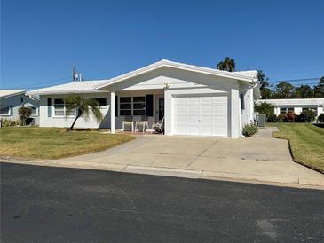 White single story home with attached garage and carport, nicely landscaped lawn at 14165 89Th Ave, Seminole, FL 33776