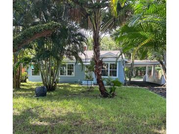 Charming light blue house with lush landscaping and a spacious front yard at 1714 2Nd E Ave, Bradenton, FL 34208