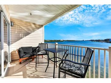 Spacious balcony with water views, table and chairs, and seating area at 19811 Gulf Blvd # 102, Indian Shores, FL 33785