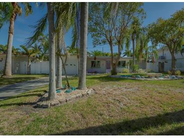 Charming Florida home with palm trees and unique landscaping at 2469 Baywood W Dr, Dunedin, FL 34698