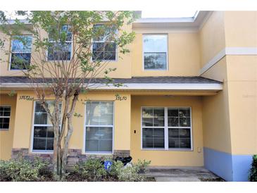 Two-story yellow house with a covered entryway and landscaping at 37670 Aaralyn Rd, Zephyrhills, FL 33542