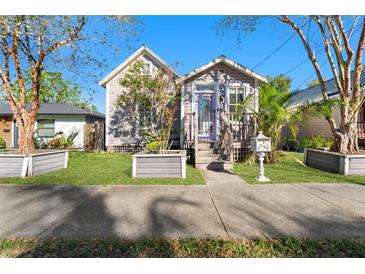 Charming single-story home featuring a quaint front porch, inviting entrance, and well-maintained landscaping at 408 E Amelia Ave, Tampa, FL 33602