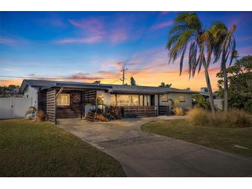 Mid-century modern home with updated facade, carport, and landscaped yard at 5201 40Th S St, St Petersburg, FL 33711