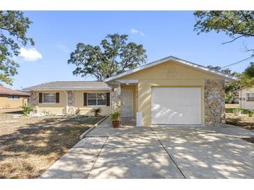 Ranch style home with stone accents and a two-car garage at 7103 Landmark Dr, Spring Hill, FL 34606