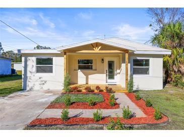 Charming single-story home featuring a covered porch and professionally landscaped front yard at 712 E Madison St, Plant City, FL 33563