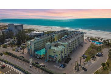 Stunning aerial view of a beachfront condo complex with turquoise waters and white sandy beaches at 12000 Gulf Blvd # 208-S, Treasure Island, FL 33706