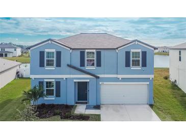 Two-story house with blue exterior, white garage door, and landscaping at 12783 Maple Bonsai Dr, Riverview, FL 33579