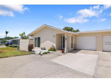 Front view of a house with a driveway, garage, and small patio at 2740 Highlands Blvd # D, Palm Harbor, FL 34684