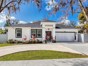 White house with gray roof, landscaping, and a circular driveway at 19212 Sunlake Blvd, Lutz, FL 33558