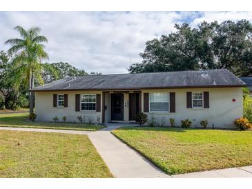 Tan house with brown roof, walkway, and landscaping at 4215 E Bay Dr # 104, Clearwater, FL 33764