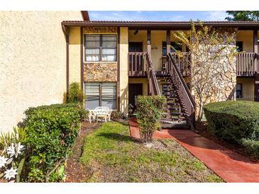 Inviting two-story condo featuring stone accents, well-kept landscaping and outdoor seating area at 7725 Forest Trl # 2, Port Richey, FL 34668