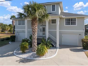 Two-story house with gray siding, palm tree, and a circular driveway at 3344 Gardenia Dr, Hernando Beach, FL 34607