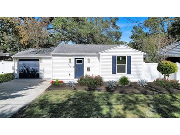 Charming remodeled home with landscaped yard, new navy blue door, and modern garage at 609 W Henry Ave, Tampa, FL 33604