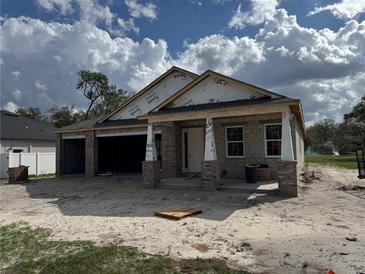 New construction home with a brick columned porch and an attached two-car garage awaiting finishing touches at 413 Shannon Estates Ct, Plant City, FL 33563