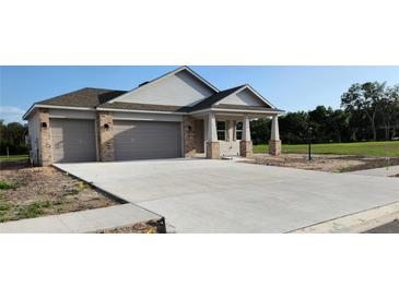 Charming new construction home featuring a three car garage and covered front porch at 413 Shannon Estates Ct, Plant City, FL 33563