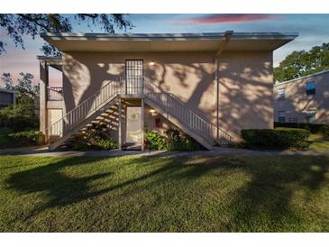 Two-story condo building with stairs and grassy yard at 4715 Michael Ct # 136, Tampa, FL 33614