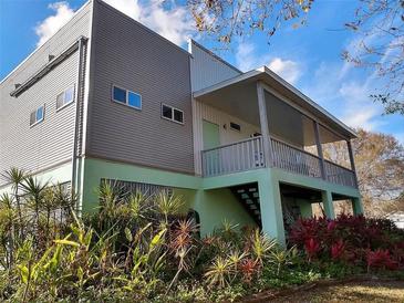 Two story home with gray and teal siding, covered porch and landscaping at 155 Guava St, Punta Gorda, FL 33980