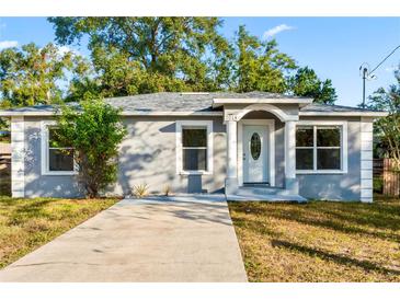 Newly renovated 1-story home with a gray exterior, white trim, and a concrete driveway at 2014 E Seward St, Tampa, FL 33604